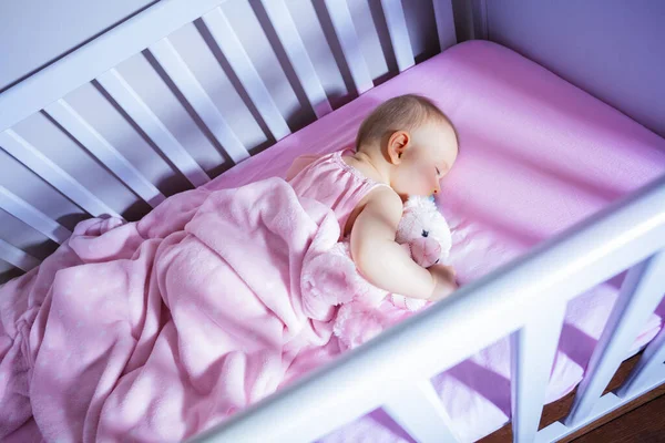 소녀가 분홍색 요람에 장난감을 잠자리에 — 스톡 사진