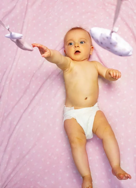 Klein Schattig Meisje Bereiken Met Hand Mobiel Speelgoed Opknoping Een — Stockfoto