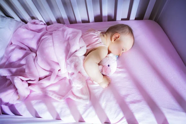 View Little Baby Girl Sleep Hugging Pink Bear Crib Bed — Stockfoto