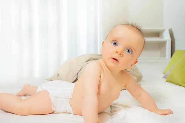 小さな赤ちゃんの女の子は腹に横たわり 興味のある表情でカメラに頭を回します — ストック写真