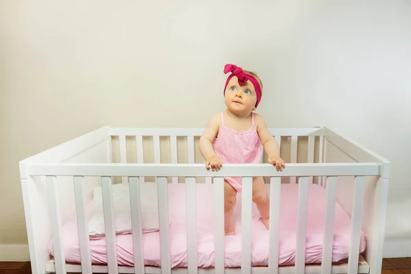 Thoughtful Baby Girl Stand Crib Bed Smiling Looking Wearing Red — Stockfoto