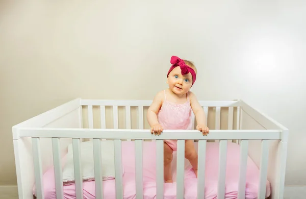 Happy Baby Girl Stand Crib Bed Smiling Wearing Red Bow — Stockfoto