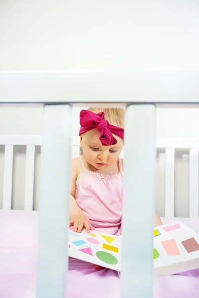 Little Baby Girl Sit Crib Look Book Shapes View Bed — Stockfoto