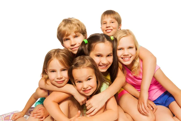 Seis crianças se sentam abraçando juntas — Fotografia de Stock