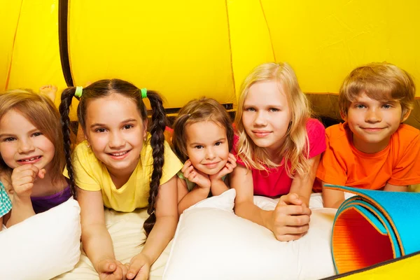 Vijf gelukkige jonge geitjes in de tent te leggen — Stockfoto