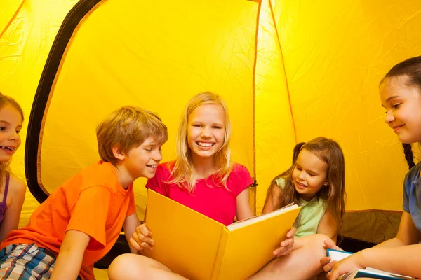 Fem barnen läsa böcker i tält — Stockfoto