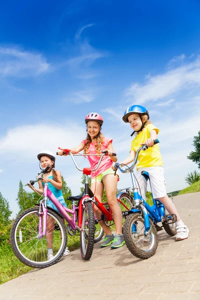 Three kid girls holding bicycles — Stock Photo, Image