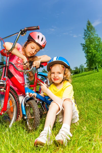 Two little girls fixing bicycles — Stock Photo, Image