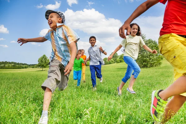 Kids running on green field — Stock Photo, Image