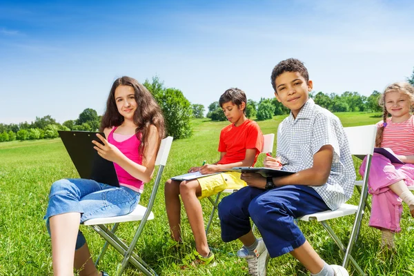Kids drawing on clipboards outside — Stock Photo, Image