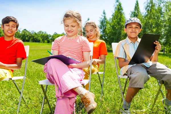 Dessiner des enfants assis sur des chaises blanches — Photo