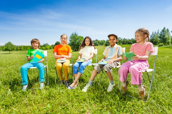 Kompisar i skolan håller övningsböcker — Stockfoto