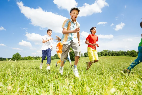 Les enfants jouent et courent dans le champ — Photo