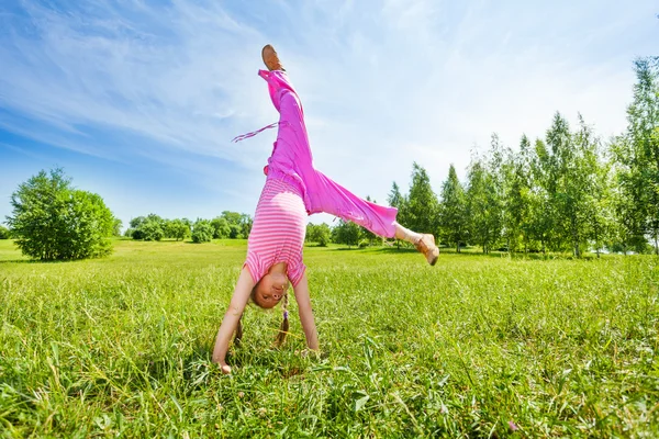 Active girl making flip on grass — Stock Photo, Image