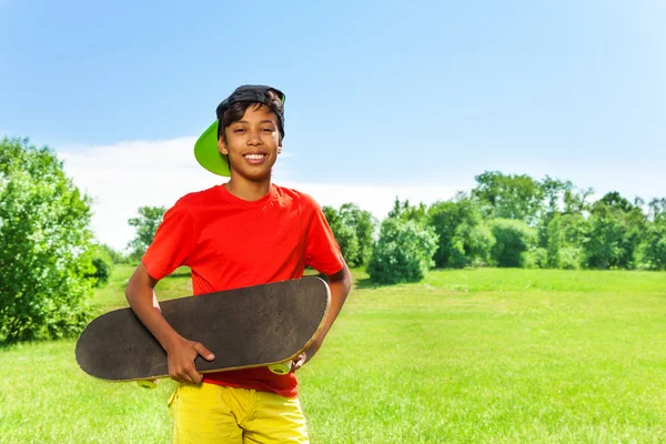 Sonriente chico con monopatín — Foto de Stock