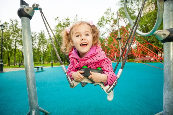 Riendo chica tendiendo y balanceándose —  Fotos de Stock