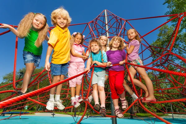 Happy kids stand on red ropes — Stock Photo, Image