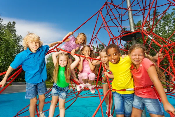 Grupo de niños de pie sobre cuerdas rojas —  Fotos de Stock