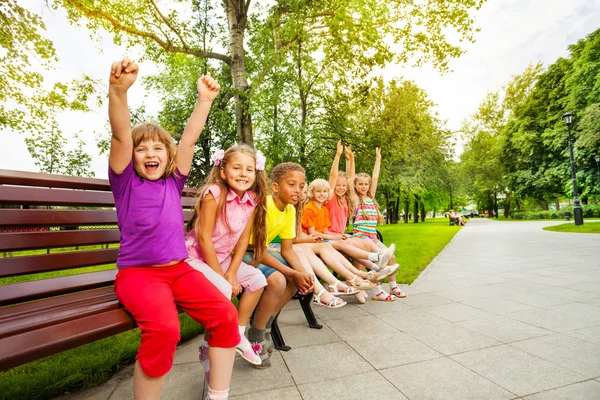 Kids sitting together on bench — Stock Photo, Image