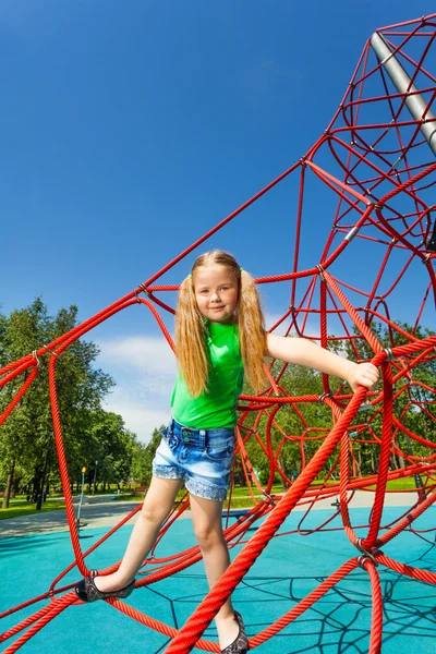 Cute girl balancing on red rope — Stock Photo, Image