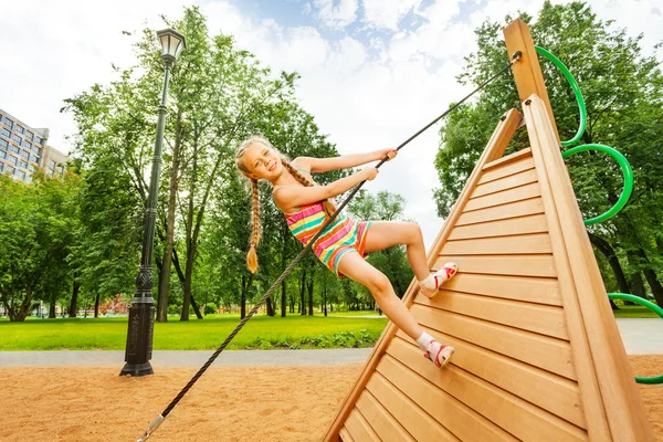 Mädchen klettert auf Holzkonstruktion — Stockfoto