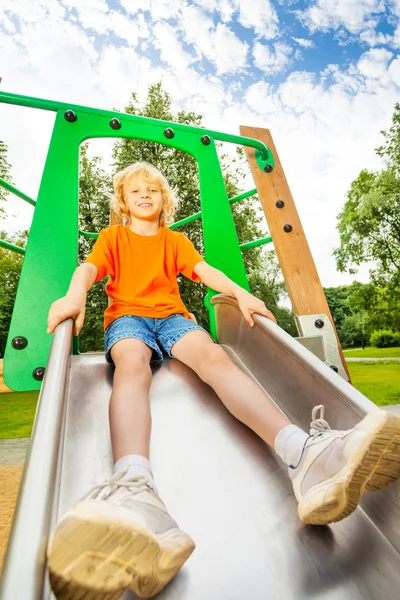 Junge rutscht auf Metallrutsche — Stockfoto