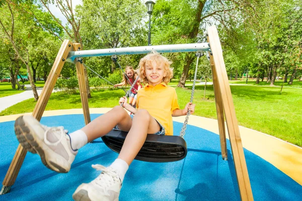 Kids swing in opposite directions — Stock Photo, Image