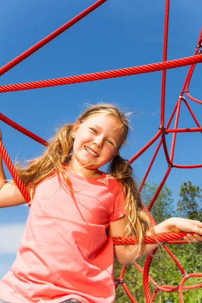 Happy girl on red rope net — Stock Photo, Image