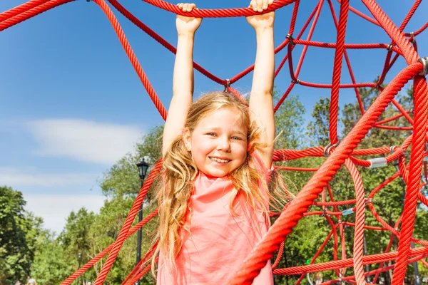 Happy girl on red rope net — Stock Photo, Image
