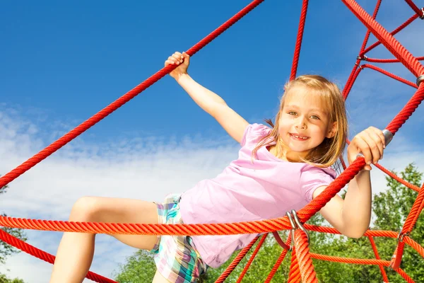 Girl on red net ropes — Stock Photo, Image