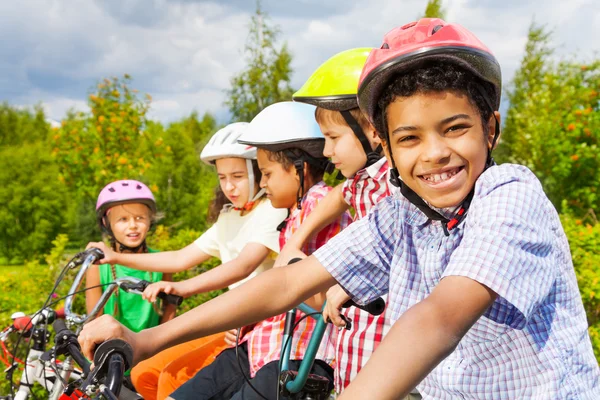 Afrikansk kille med vänner på cyklar — Stockfoto