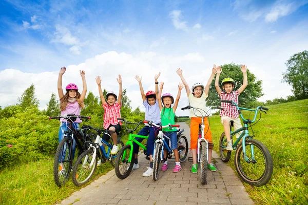 Aufgeregte Kinder mit Helmen auf Fahrrädern — Stockfoto