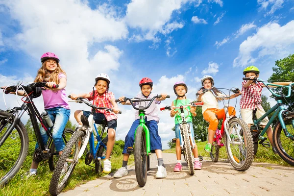 Barnen i hjälmar med cyklar — Stockfoto