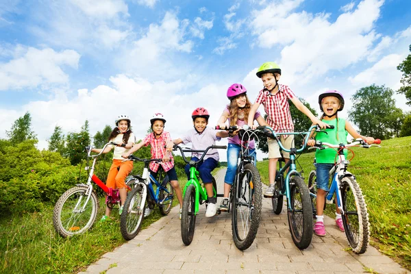 Crianças felizes em capacetes de bicicleta coloridos — Fotografia de Stock
