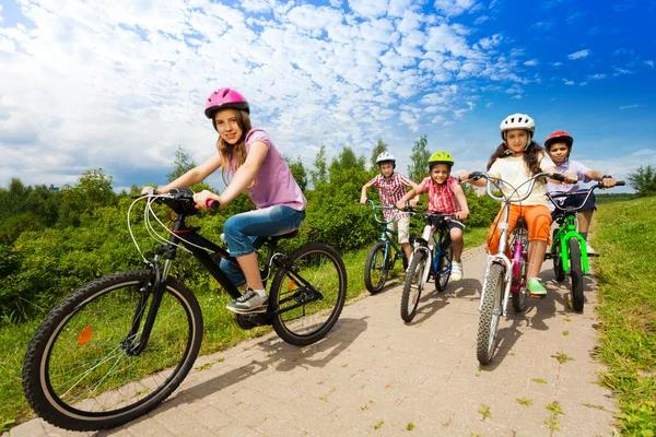 Zwei Mädchen und Jungen in Helmen — Stockfoto