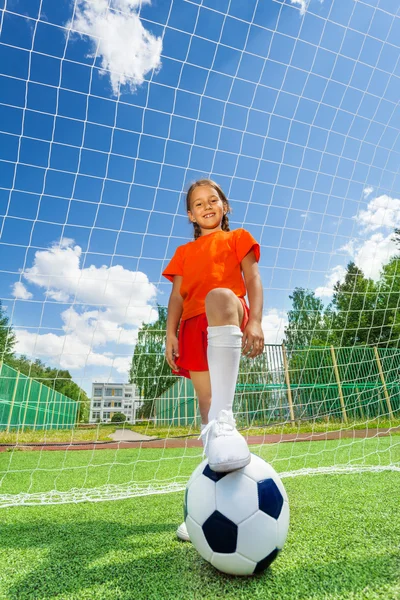 Mädchen mit Bein auf Ball — Stockfoto