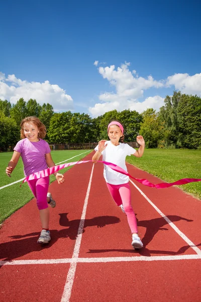 Dívky běží a dosáhnout stuha — Stock fotografie