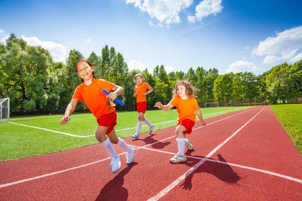 Tre ragazze con bastone in esecuzione — Foto Stock