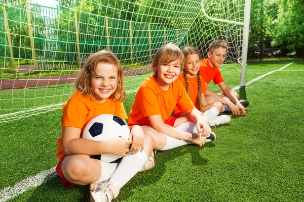 Los niños se sientan junto con el fútbol — Foto de Stock