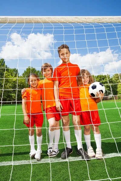 Diferentes altura niños de pie con fútbol — Foto de Stock