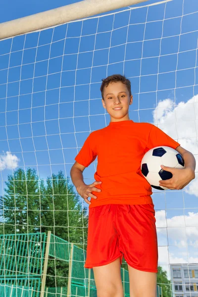 Boy with ball stands near woodwork — Stock Photo, Image
