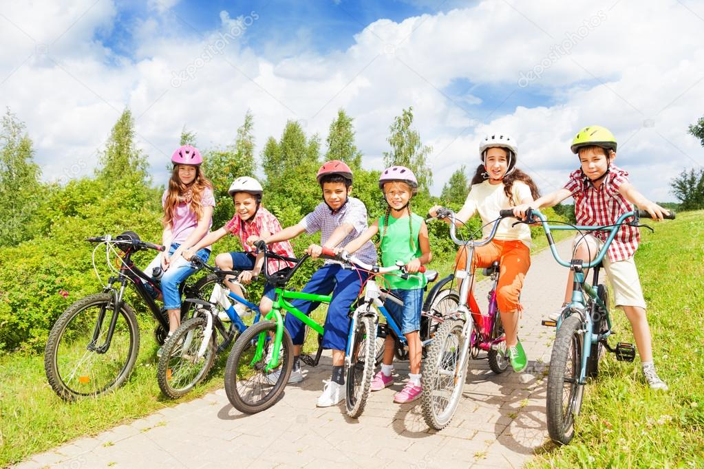 Row of kids in helmets with bikes