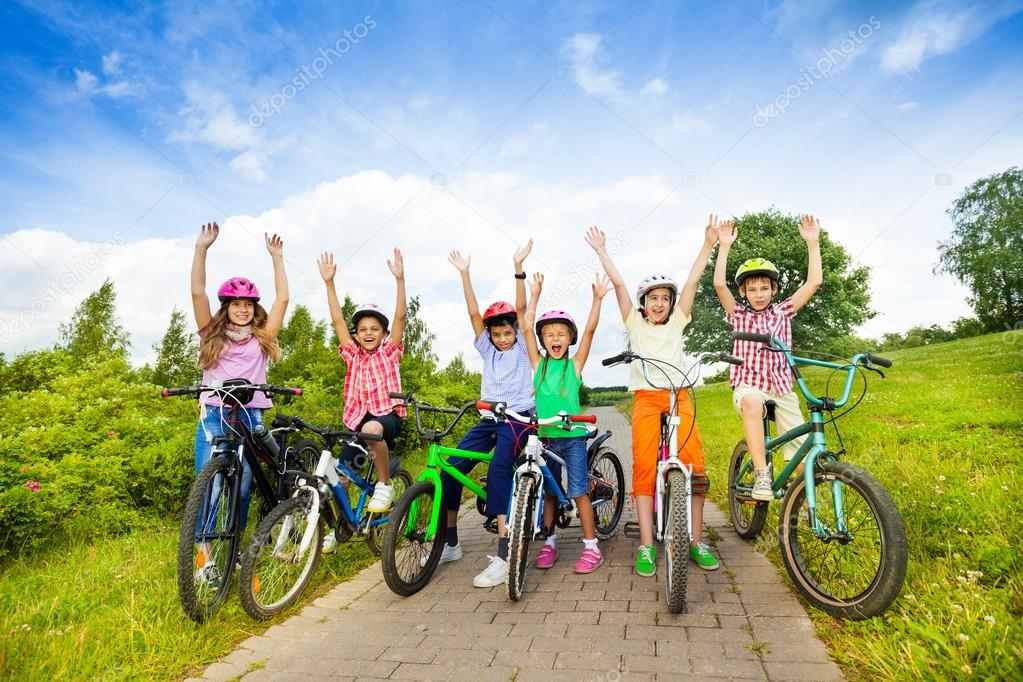 Excited kids in helmets on bikes