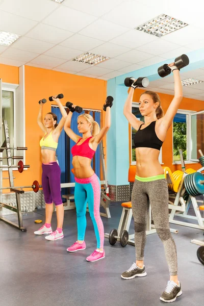 Três meninas exercitando com halteres — Fotografia de Stock