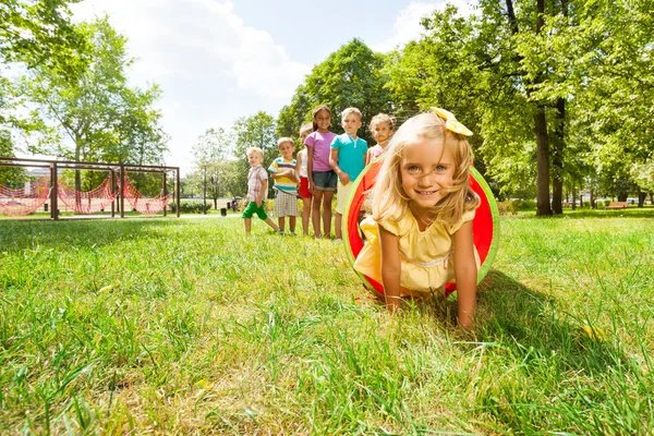 Blond girl plays in tube — Stock Photo, Image