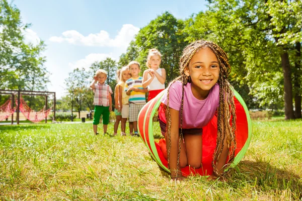 Afrikanisches Mädchen kriecht durch Röhre — Stockfoto