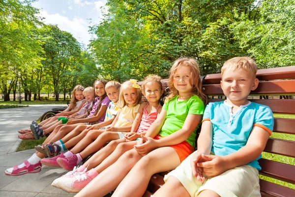 Ομάδα παιδιών που κάθεται σε παγκάκι — Φωτογραφία Αρχείου
