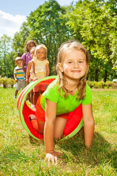 Happy girl crawls through play tube — Stock Photo, Image