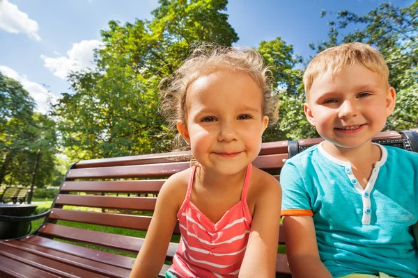 Boy and girl on bench — Stock Photo, Image