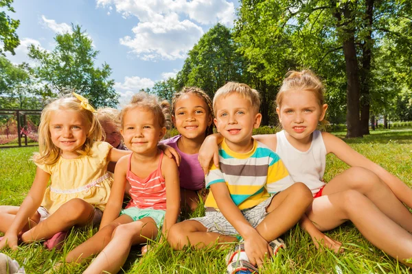 Kinderen op gazon in park Stockfoto